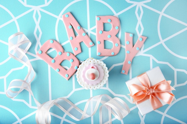 Letras de la palabra bebé y dulces en fondo azul