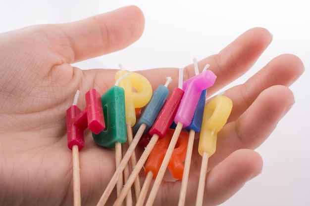 Letras de velas de cumpleaños en la mano