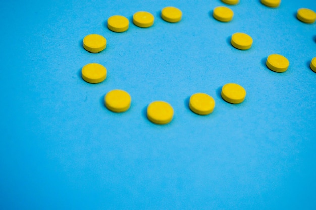 Letras volumétricas de cor amarela na forma de comprimidos em medicamentos de fundo azul postados