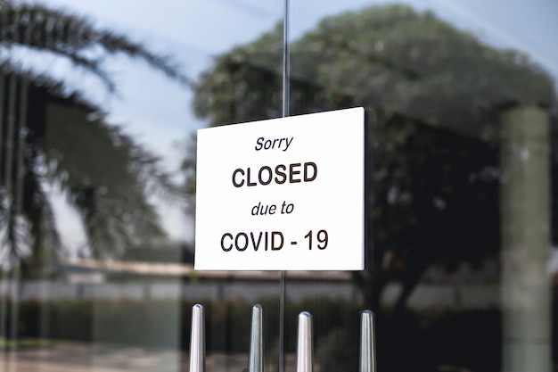 Foto el letrero frente a la oficina está cerrado temporalmente firme coronavirus en la tienda