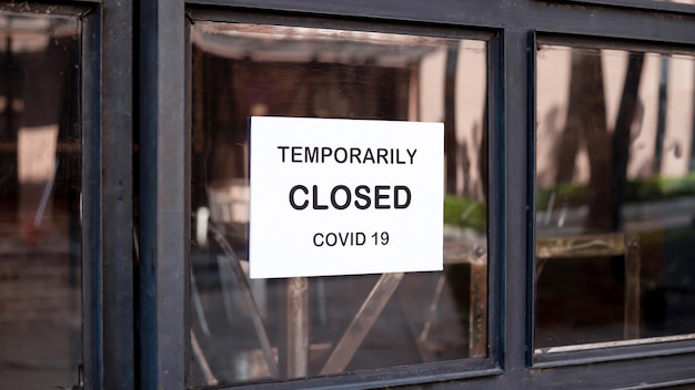 El letrero frente a la oficina está temporalmente cerrado. Firma Coronavirus en la tienda.