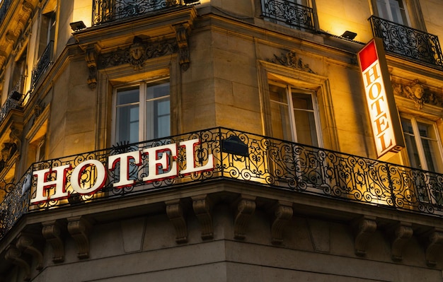 Foto letrero de hotel iluminado tomado en parís por la noche