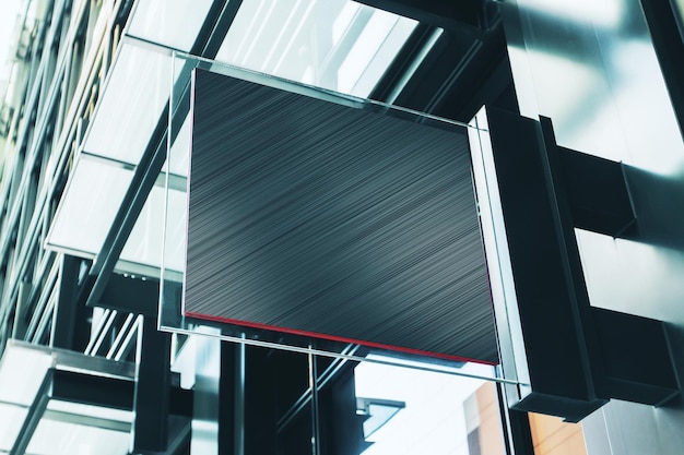 Foto un letrero de metal cuadrado negro con espacio en blanco para su logotipo en la pared de un modelo de centro comercial moderno