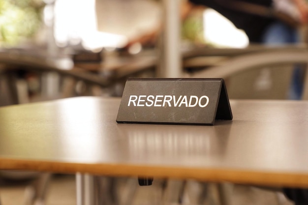 Un letrero negro que dice "reservado" se sienta sobre una mesa.