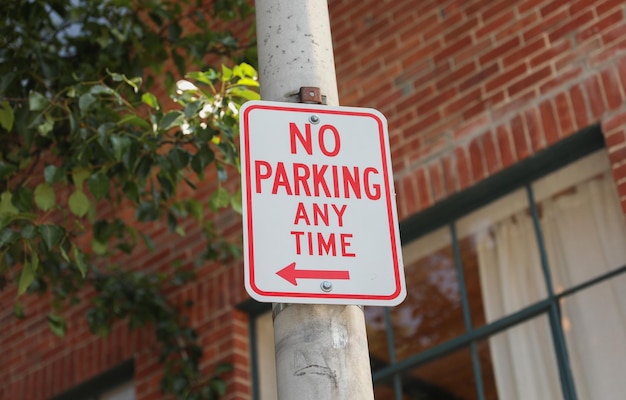 Un letrero rojo y blanco que dice que no se puede estacionar en ningún momento.