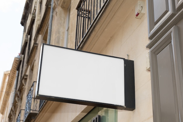 Letrero de tienda en la calle vacía y blanca para poner su marca o texto