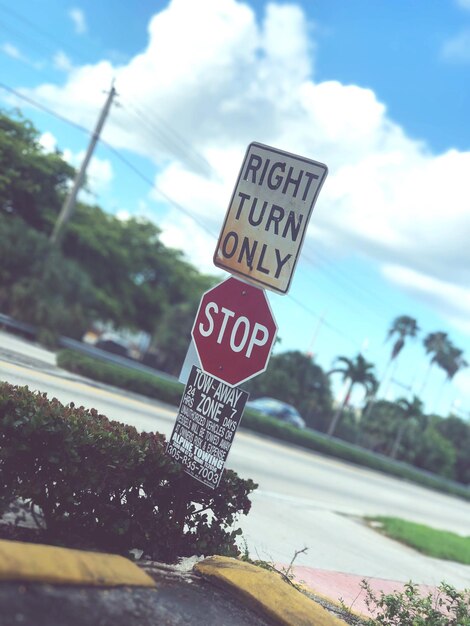 Foto letreros de carretera por la calle contra el cielo