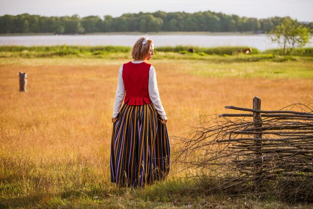 Lettische Frau in traditioneller Kleidung im Feld