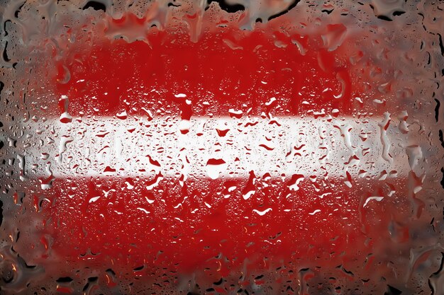 Lettland-Flagge Lettland-Flagge auf dem Hintergrund von Wassertropfen Flagge mit Regentropfen Spritzer auf Glas