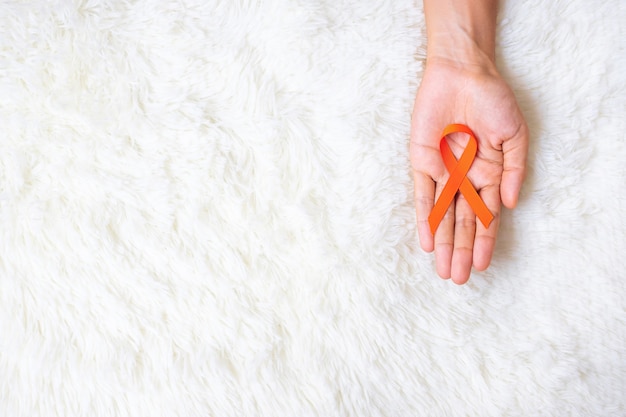 Leucemia, día del cáncer de riñón, esclerosis múltiple mundial, CRPS, mes de la conciencia de las autolesiones, cinta naranja para apoyar a las personas que viven y están enfermas. Concepto de salud y día mundial contra el cáncer