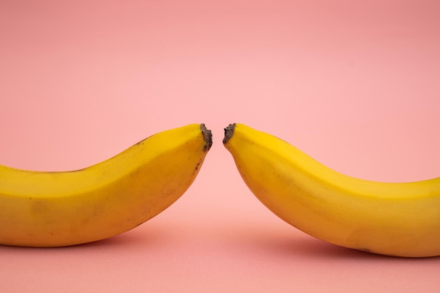 Leuchtend gelbe Bananen auf einem rosa Hintergrund