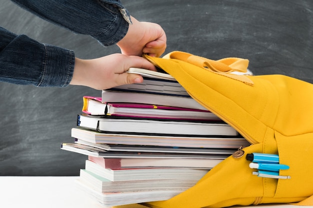 leuchtend gelber Schulrucksack voller Bücher