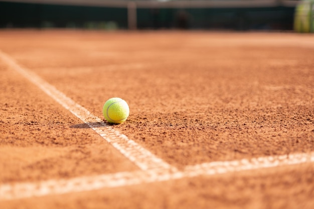 Leuchtend grünlich-gelber Tennisball auf der Linie