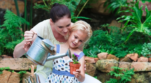 Leuchtende Mutter und Tochter, die in ihrem Garten pflanzen