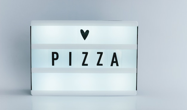 Leuchtkasten mit Text, PIZZA an weißer Wand