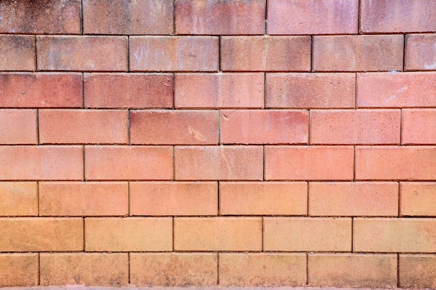 Leuchtorange Ziegelmauer mit Stapeln von Blöcken als Hintergrund