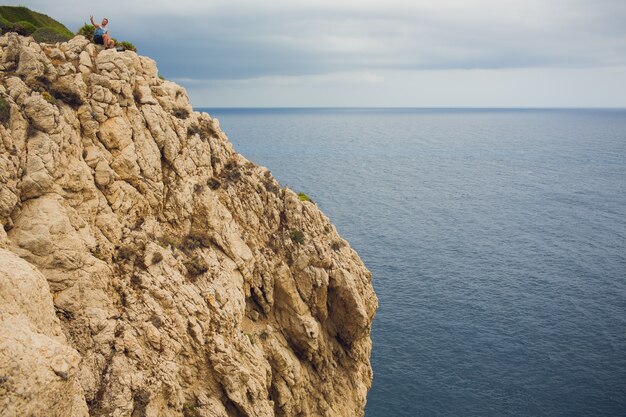 Leuchtturm am Kap Formentor in der Küste von Nord-Mallorca, Spanien. Junger Mann des künstlerischen Sonnenaufgangs und der Dämmerungslandschaft auf dem Berg
