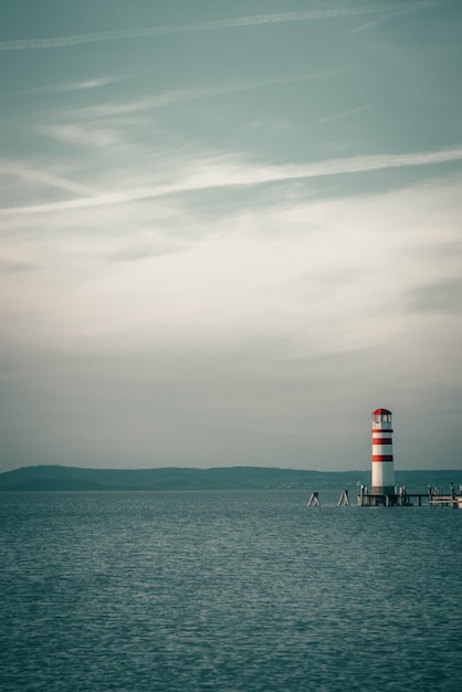 Leuchtturm am Meer gegen den Himmel beim Sonnenuntergang