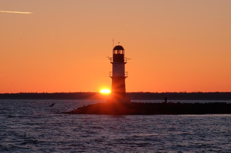 Foto leuchtturm am meer gegen den himmel beim sonnenuntergang