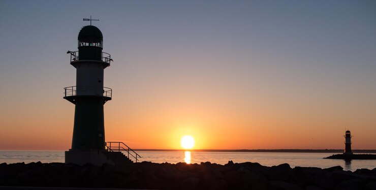Foto leuchtturm am meer gegen den himmel beim sonnenuntergang