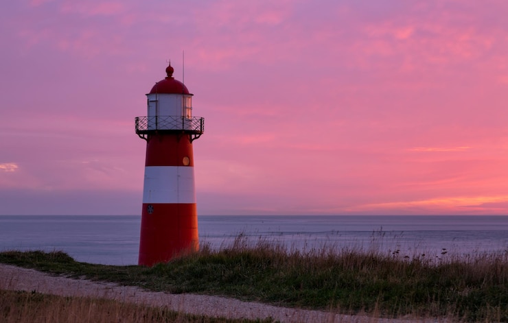 Foto leuchtturm am meer gegen den himmel beim sonnenuntergang