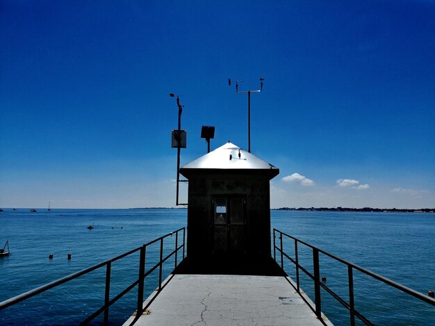 Leuchtturm am Meer gegen den klaren blauen Himmel