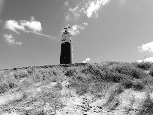 Foto leuchtturm auf dem feld durch gebäude gegen den himmel