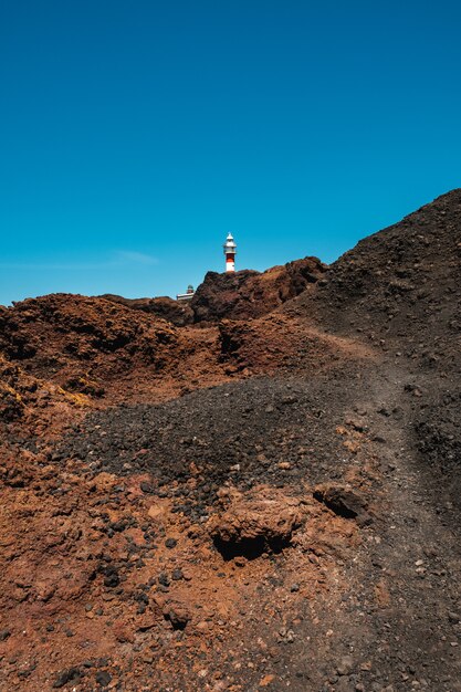 Foto leuchtturm, der hinter einem berg darstellt