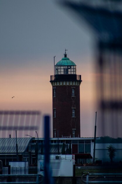 Foto leuchtturm inmitten von gebäuden in der stadt bei sonnenuntergang