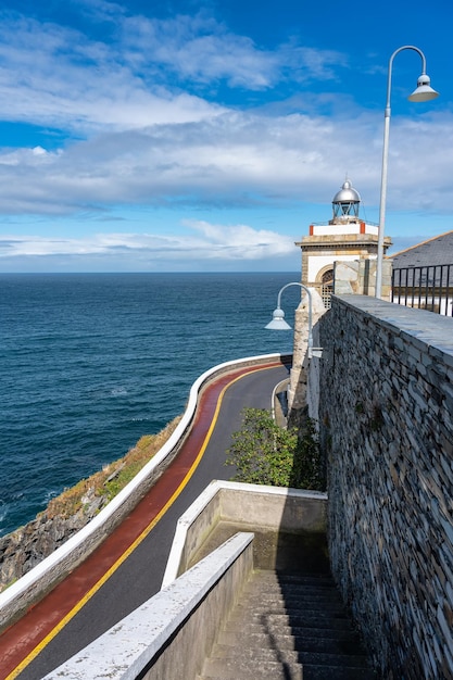 Leuchtturm und Haus der Person, die sich um ihn kümmert, auf den Klippen des Kantabrischen Meeres Luarca Spanien