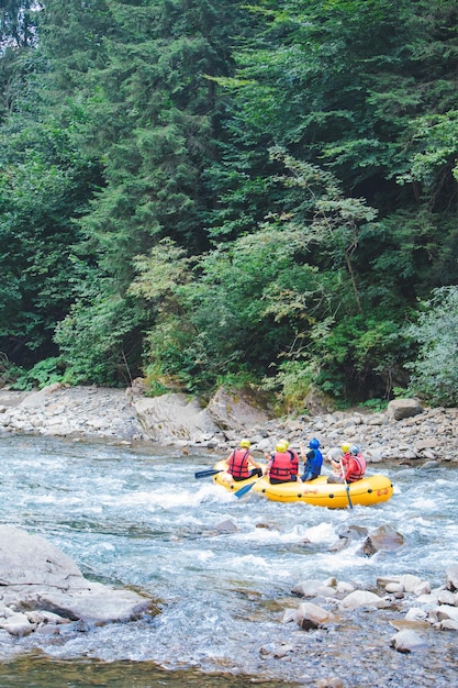 Leute, die am Gebirgsflusskopienraum Rafting machen