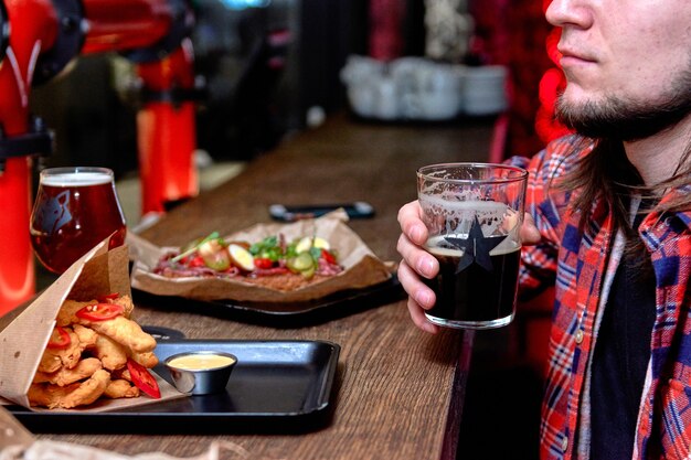 Leute, die beim Fast Food essen, verbringen Zeit zusammen im Café, im Bierlokal. Köstliche Abendessen-Nuggets im Restaurant auf einem Holztisch.