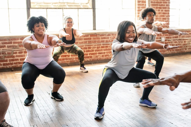 Leute, die im Fitnesskurs Kniebeugen machen