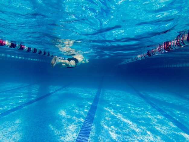 Leute, die im Poolblick von der Unterwasserwelt schwimmen