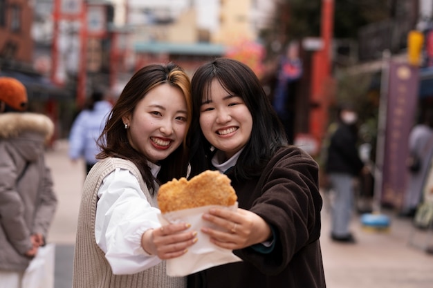 Foto leute, die japanisches straßenessen genießen