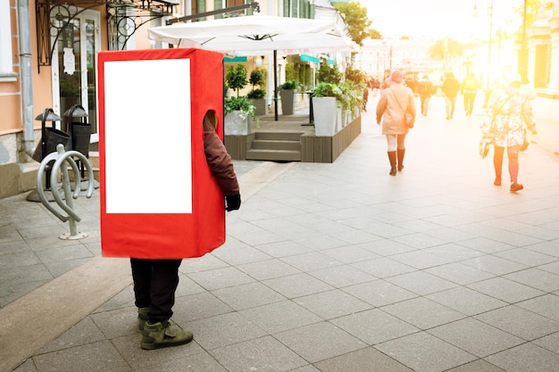 Foto leute, die rotes kastenkostüm der werbung tragen werbemodell auf der straße.