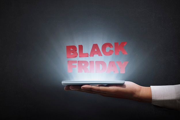 Leute, die Tablette halten und Black Friday-Anzeige zeigen