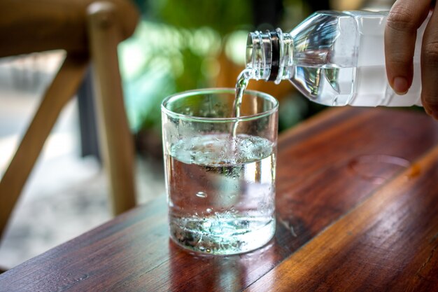 Leute gießen Wasser in das Glas