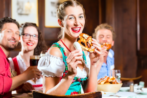 Leute in bayerischem Tracht essend im Restaurant oder in der Kneipe