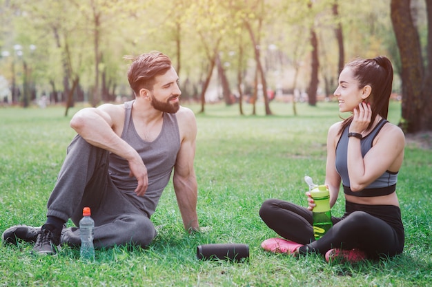 Leute sitzen zusammen auf Gras und ruhen sich aus