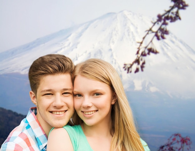 leute, urlaub, liebe und reisekonzept - lächelndes paar, das über japan-gebirgshintergrund umarmt