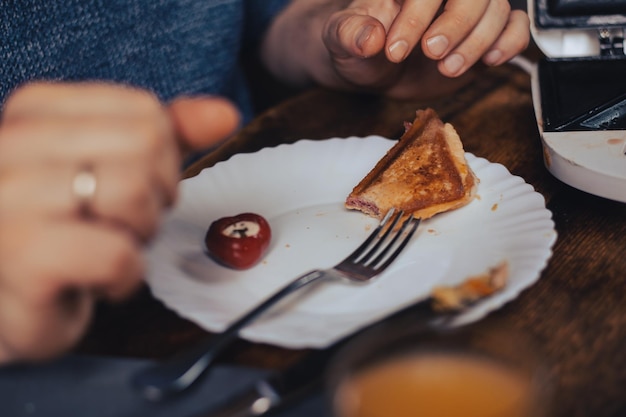 Levando comida Um homem irreconhecível está sentado em frente a um prato com restos de comida