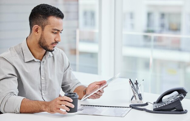 Levando meu trabalho comigo em movimento Foto de um jovem empresário usando um tablet digital no trabalho