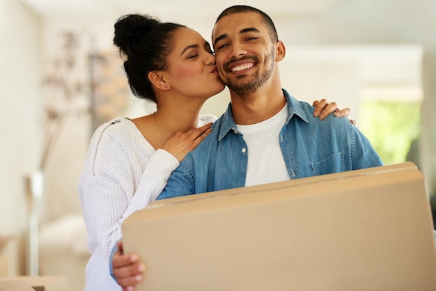 Levando seu relacionamento a um nível totalmente novo retrato de um jovem casal feliz carregando caixas de papelão em sua nova casa