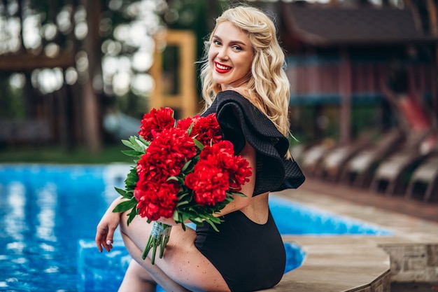 Levanta a loira com estilo em traje de banho vintage preto relaxante na piscina ao ar livre