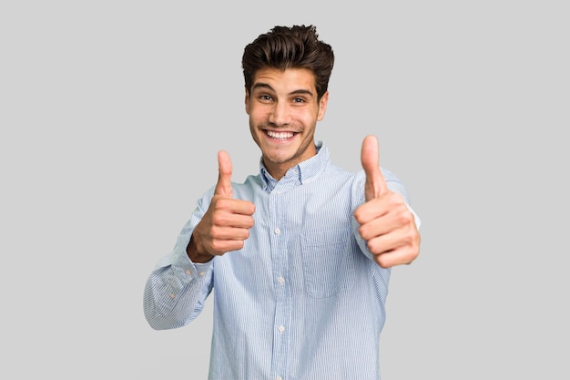 Levantando ambos pulgares sonriendo y confiado