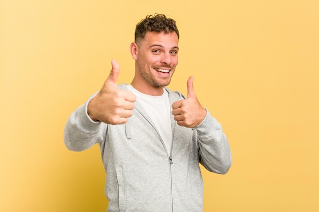 Levantando os dois polegares para cima sorrindo e confiante