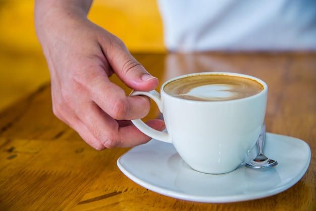 Levante um copo de café para beber.