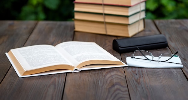 Leyendo libros sobre la mesa del jardín.