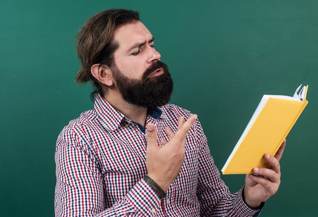 Foto leyendo el poema. hombre poético con barba leyendo el libro. proceso de estudio. educación no formal. estudiante masculino en el aula de la escuela en la lección de literatura. pasar el examen. aprender el tema.